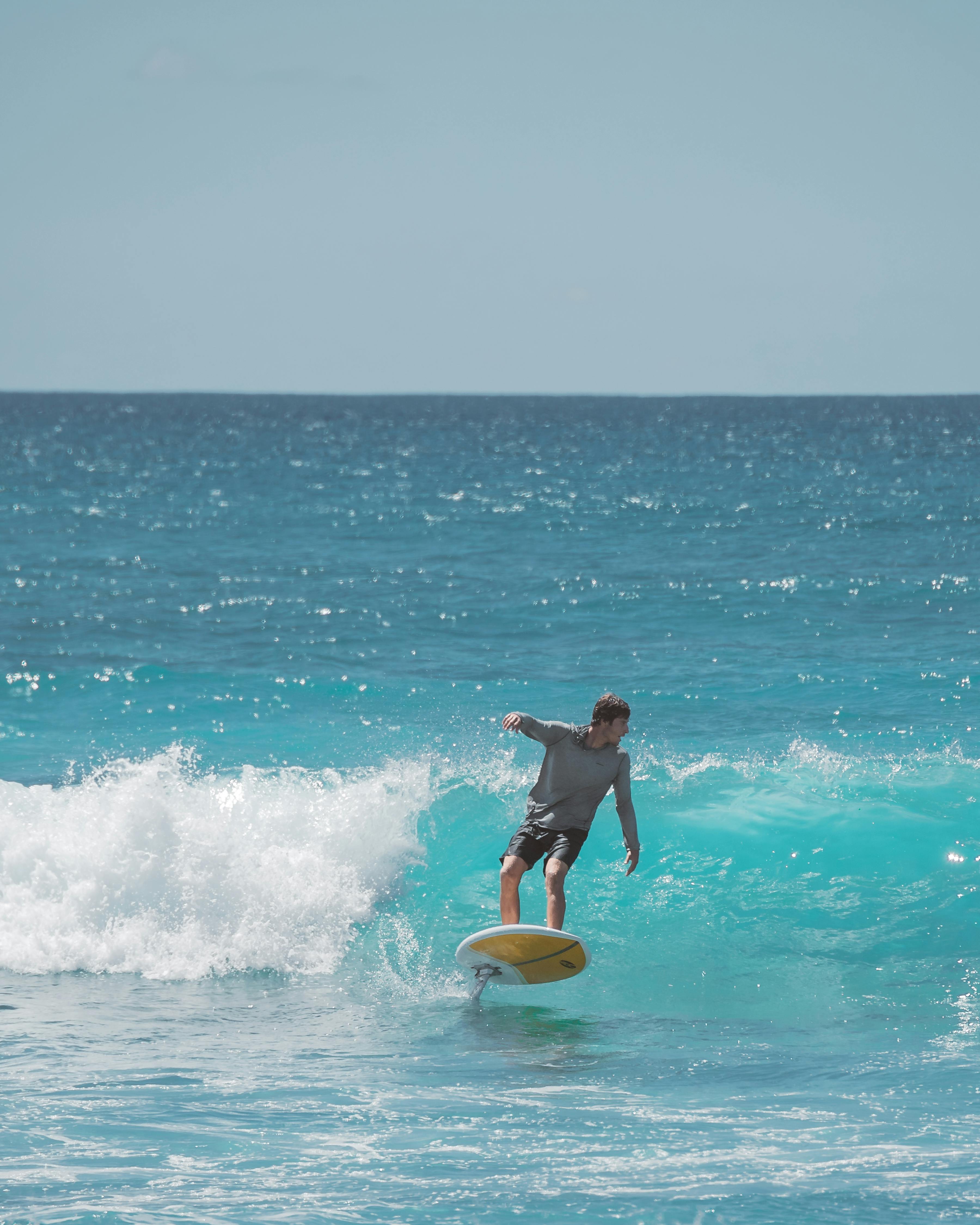 A prone foiler surfing on a blue wave.